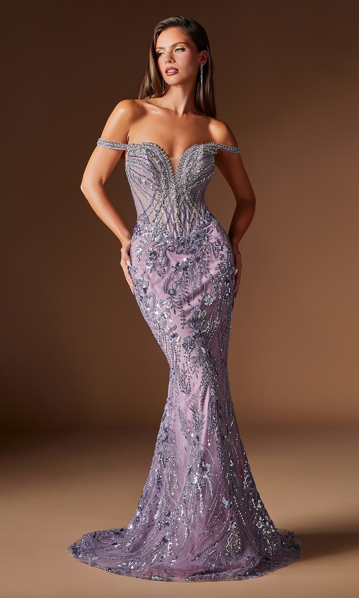 A woman poses in the Ladivine CDS570 long prom dress, featuring an off-the-shoulder lavender design with silver embroidery and beadwork, set against a brown background.